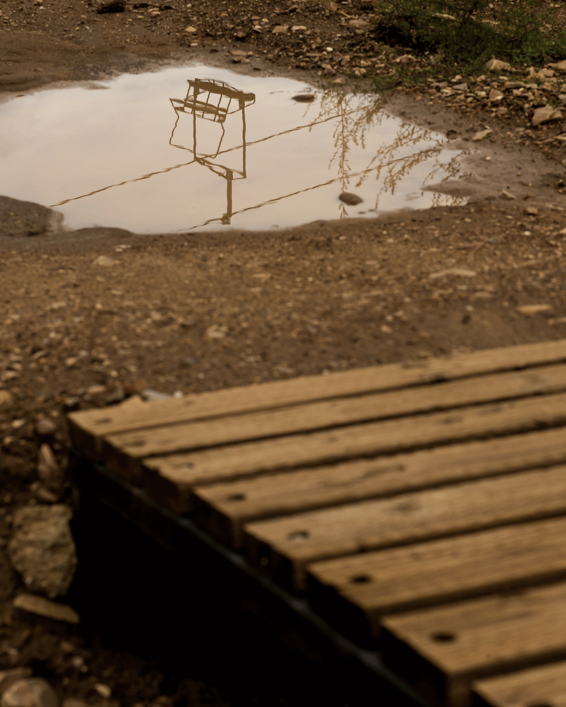 Rain, mud, reflection of a chairlift